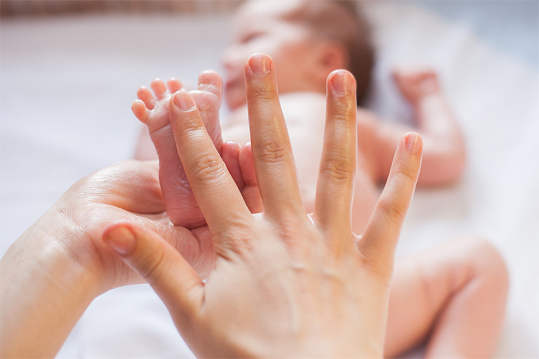 Massage bàn chân của trẻ sơ sinh bằng tinh dầu tràm trước khi đi ngủ để thư giãn cơ thể, giúp trẻ ngủ sâu giấc hơn