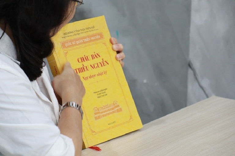 Bác sĩ Nguyễn Thị Vân Anh cầm trên tay cuốn Châu Bản Triều Nguyễn - Ngự Dược Nhật Ký 